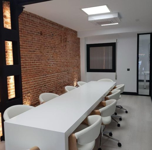 sala de juntas con mesa larga con sillas en blanco